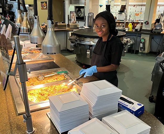 Passage USA Student serving food to USA students at the school cafeteria.