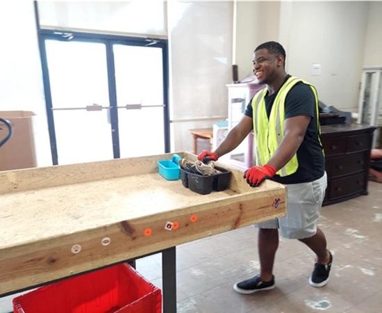 Passage USA student helping move equipment during their internship.