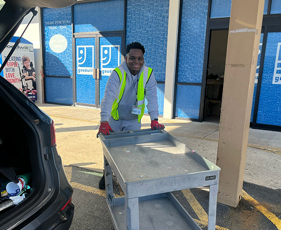 Passage USA Student picking up clothes at Goodwill.