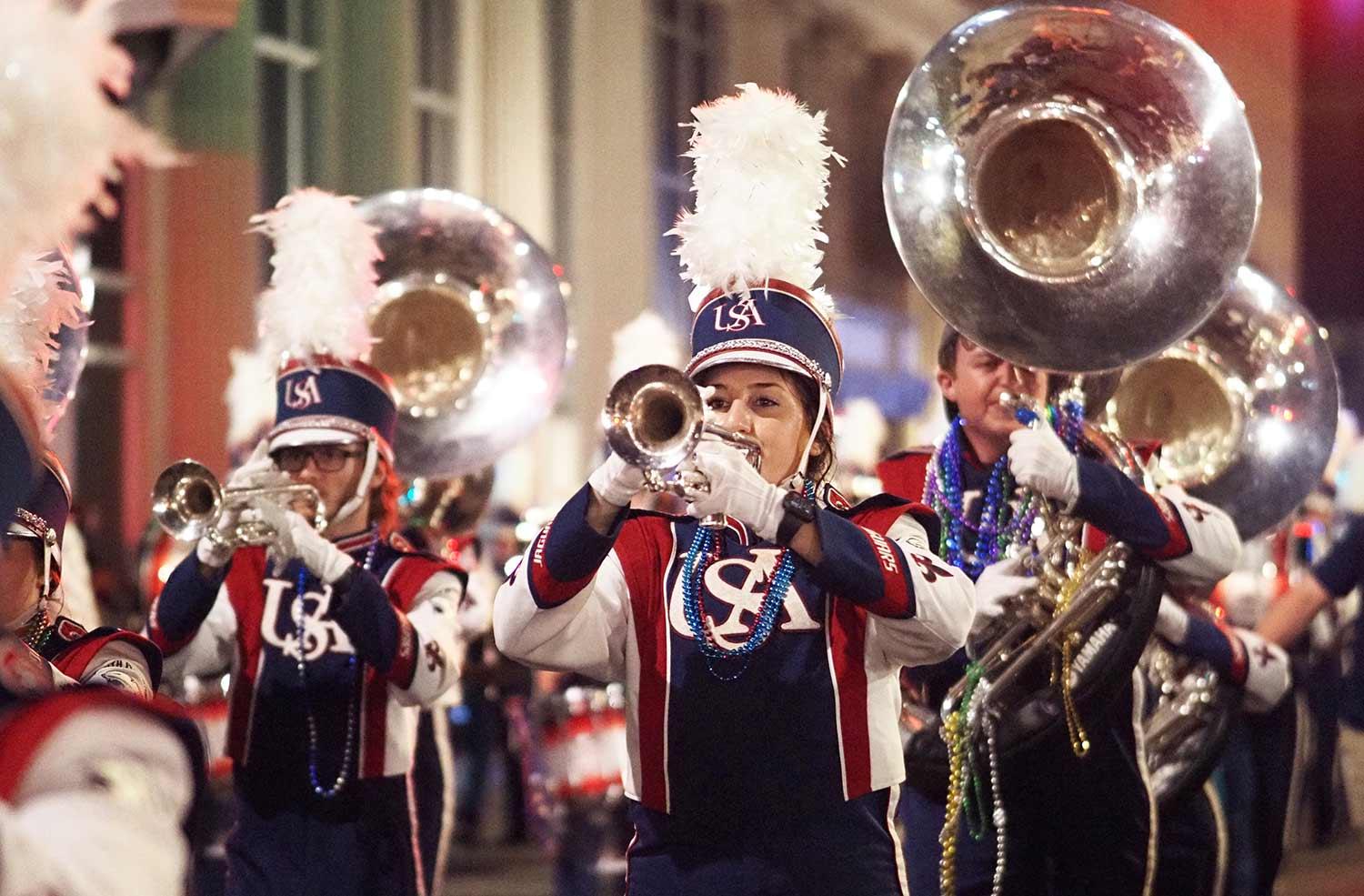Tuba players marching in the street during the Mardi Gras parade.