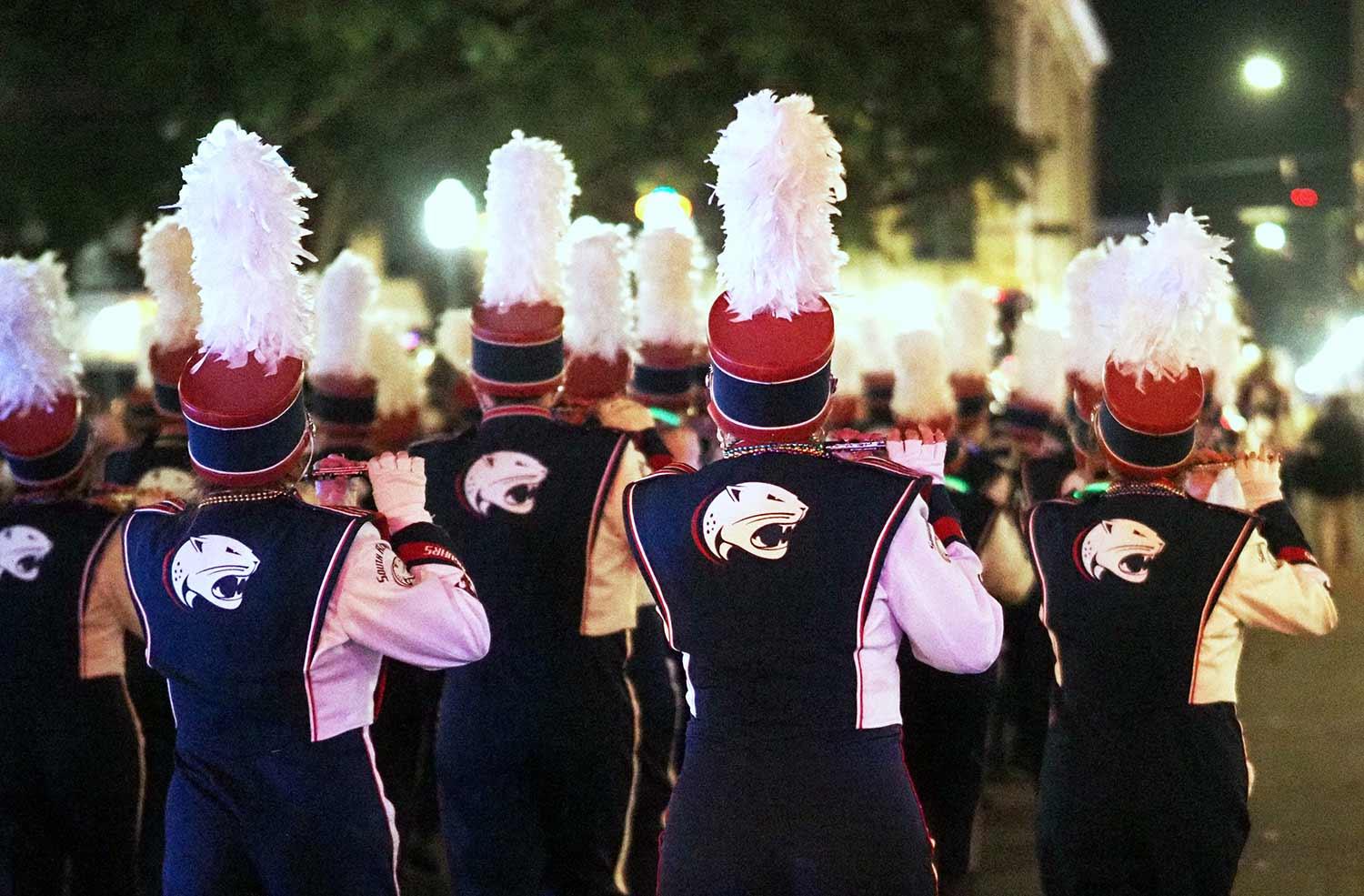 Back of marching band marching in parade.