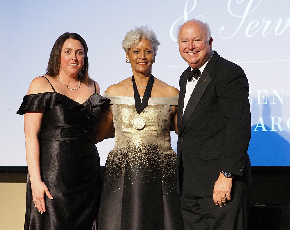 Mrs. Margie Malone Tuckson standing with President Bonner and Alumni president.