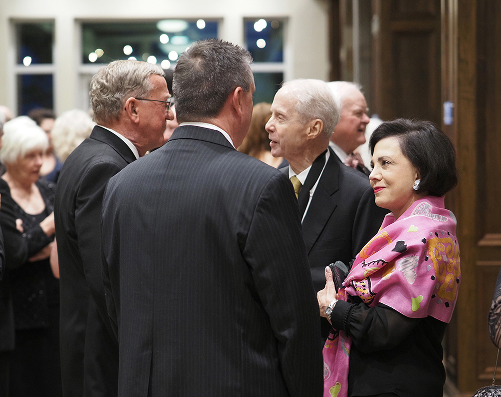 A group of people talking at reception.