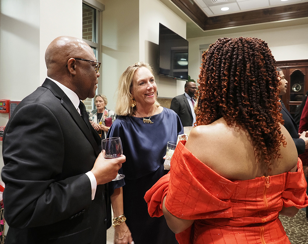 Three people talking at Distinguished Alumni awards reception.