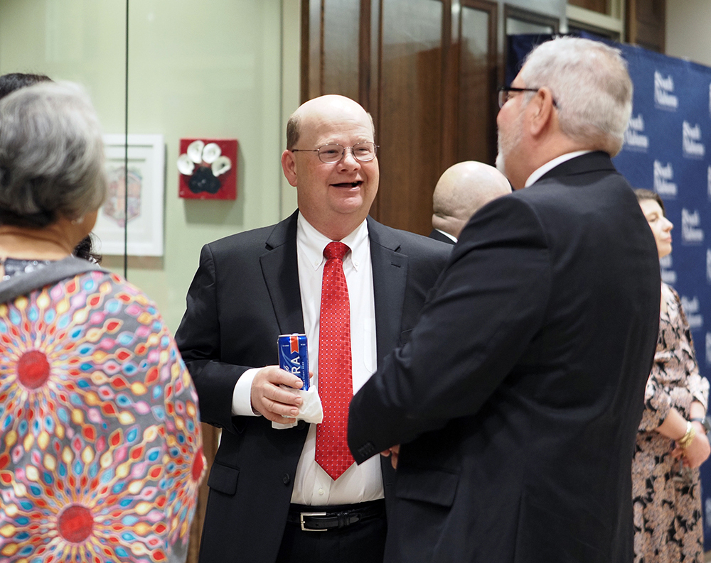 Faculty talking to others at reception.