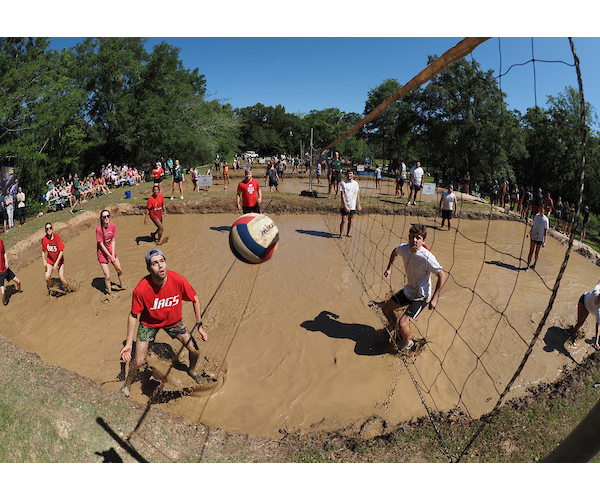 Group image of students playing oozeball with ball in air.