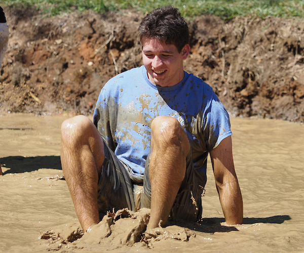Student sitting in the muddy water.