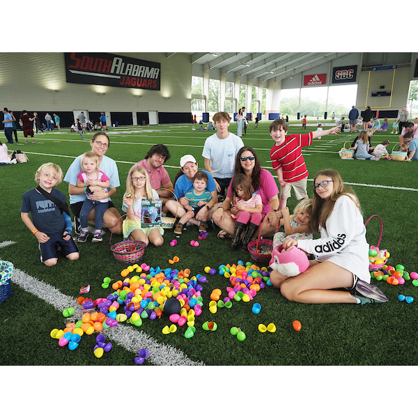 A group of children and parents showing the eggs they found