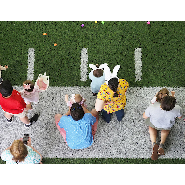 kids line up on the football field for the egg hunt