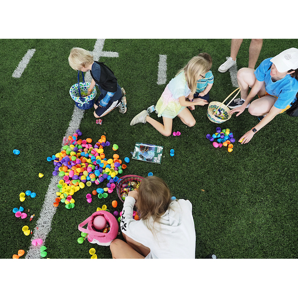 children and parents looking at a pile of Easter eggs