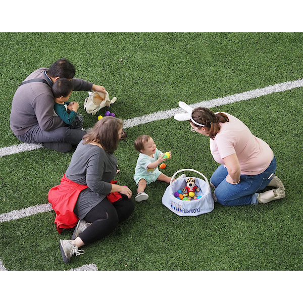 children and parents laying on the field