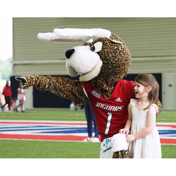 southpaw posing and pointing down the field with a child