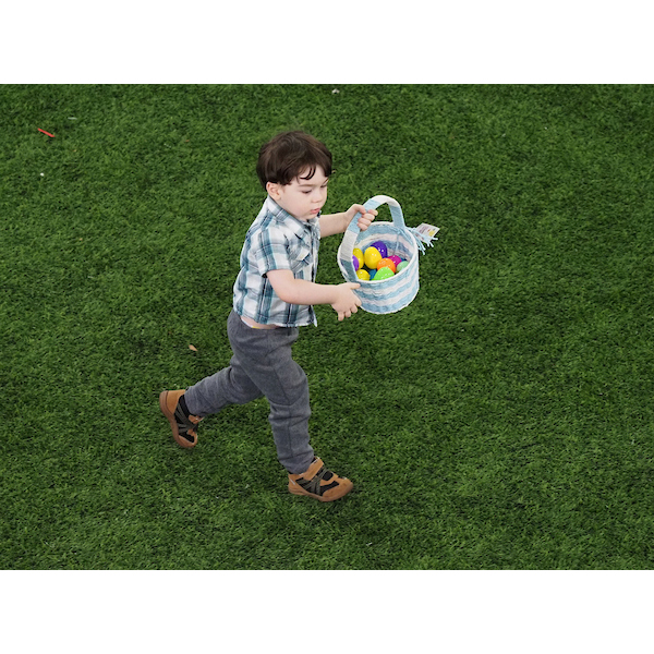 boy running down the field with an easter basket