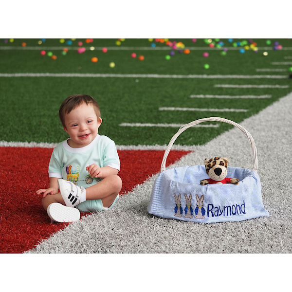 boy toddler posed on the field with an easter basket with a southpaw doll