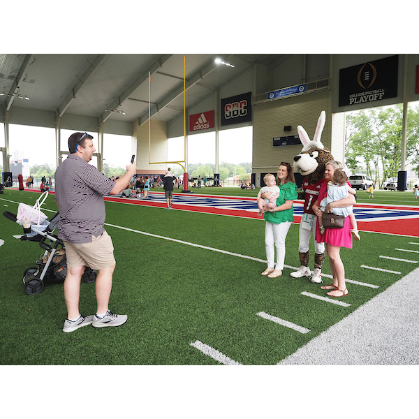 father taking a picture of his kids posing with southpaw