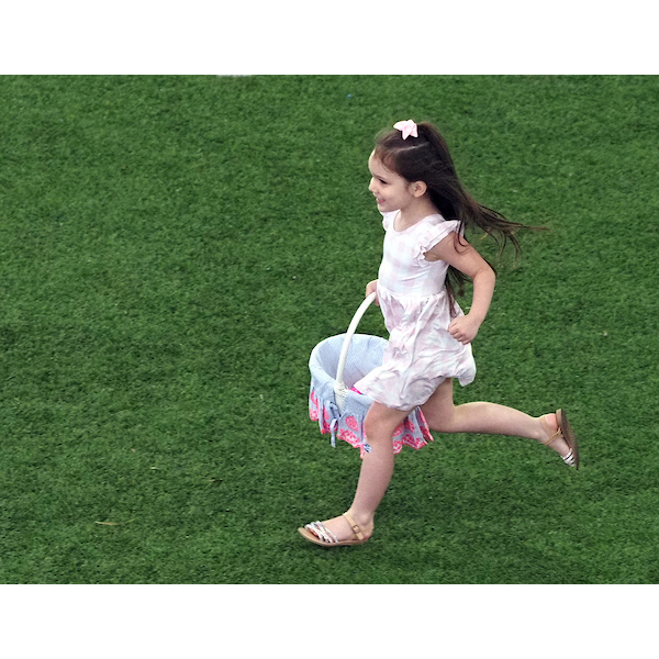 Girl running down the field with an easter basket