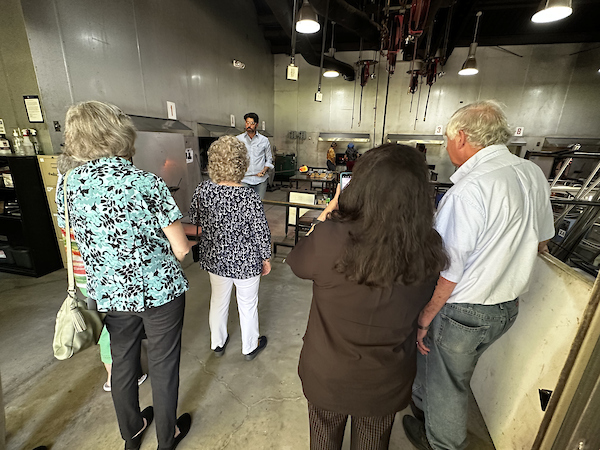 people being shown a glass working shop