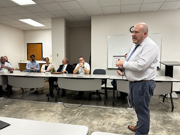 picture of the port city craftsman check meeting, a man speaking in front of the setup