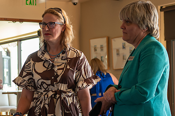 Two women standing at alumni event.