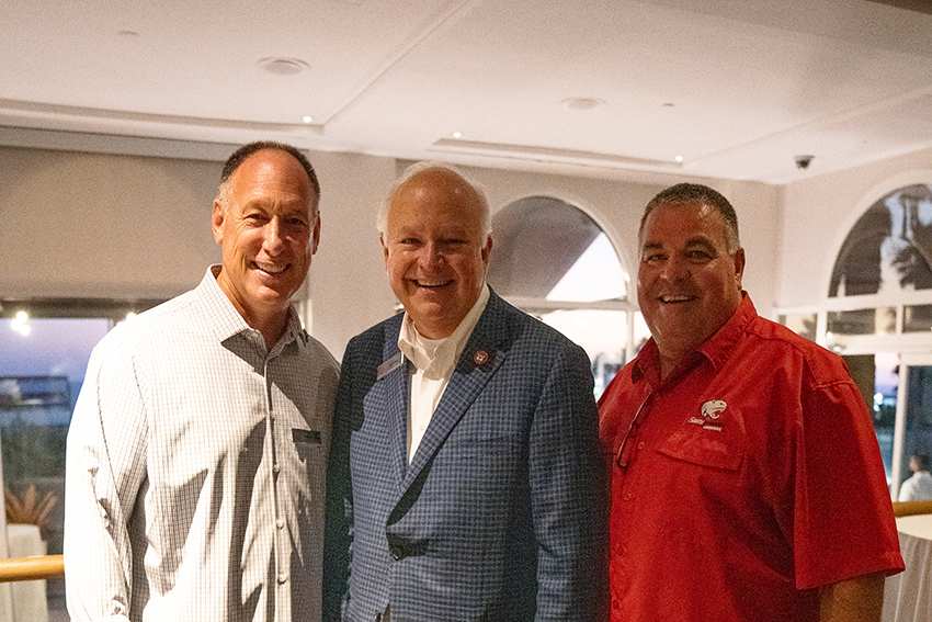 President Bonner with two alumni on either side of him.