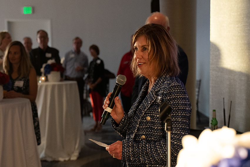 Margaret Sullivan holding mic speaking at event.