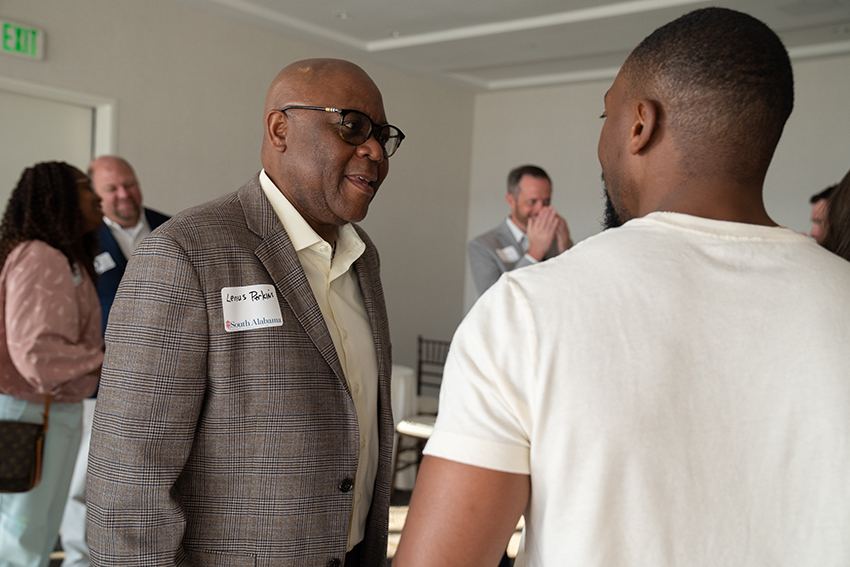 Two men speaking at event.