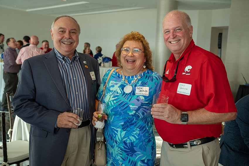 Group of three alumni smiling.