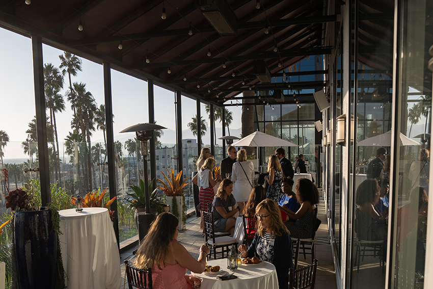 Set up of event displaying table with glass windows in background.