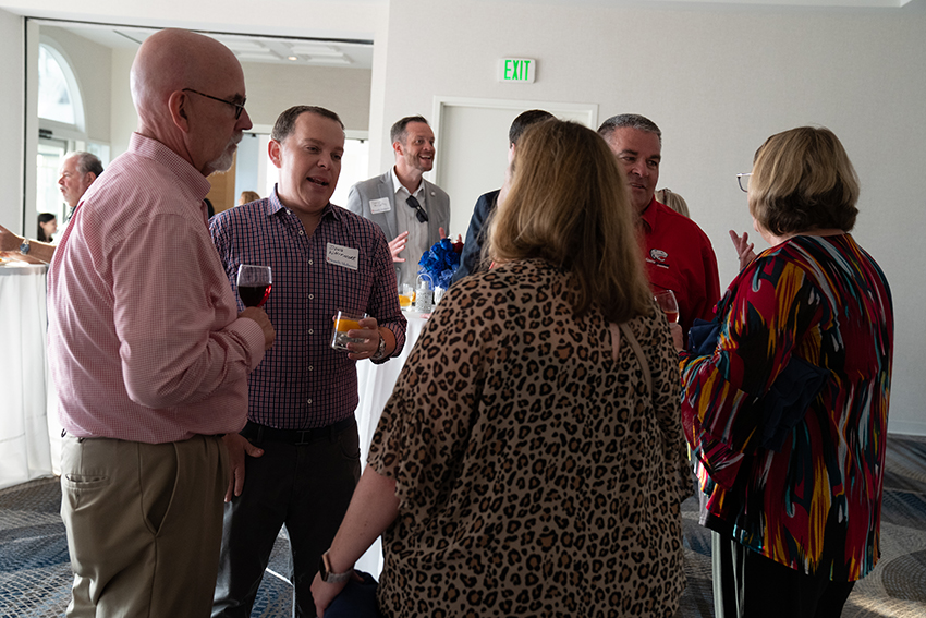 Crowd shot of alumni talking.