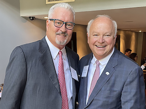 President Jo Bonner with an alumnus smiling for a picture.