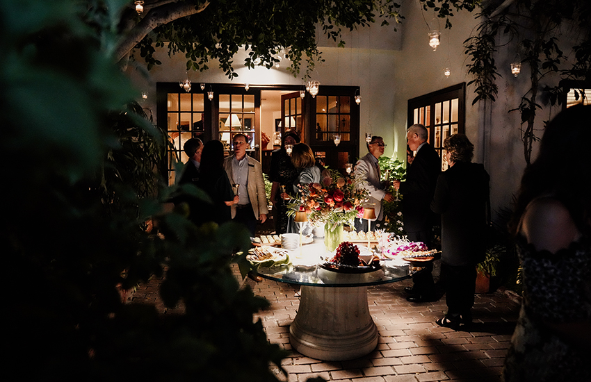 Crowd shot of dinner table and alumni talking.