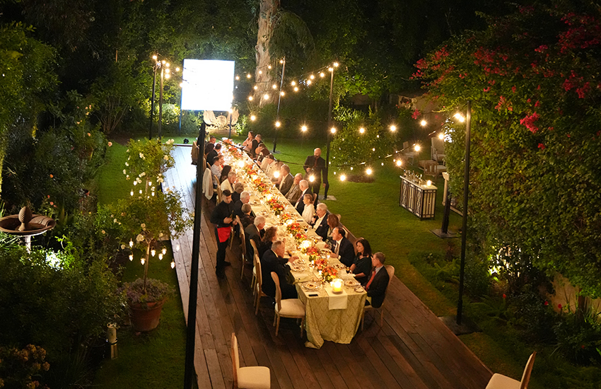 Aerial shot of everyone at dinner table outside. 