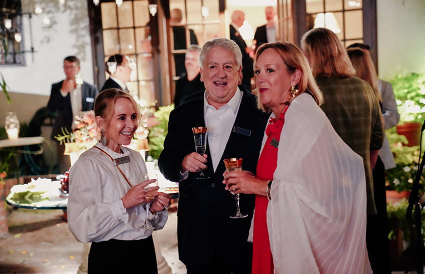 First lady and alumni outside holding wine glasses.