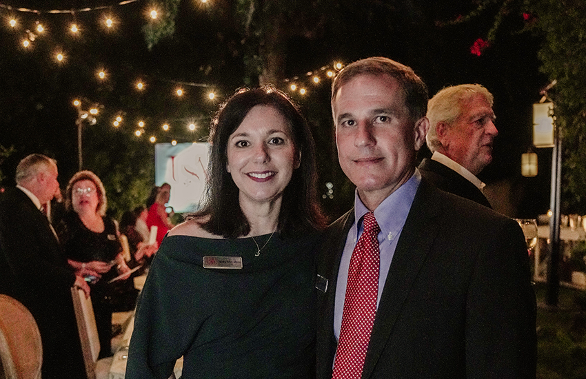 Couple standing under lights at event.