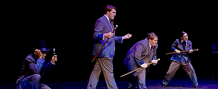 USA Students acting on stage in a play with players holding canes.