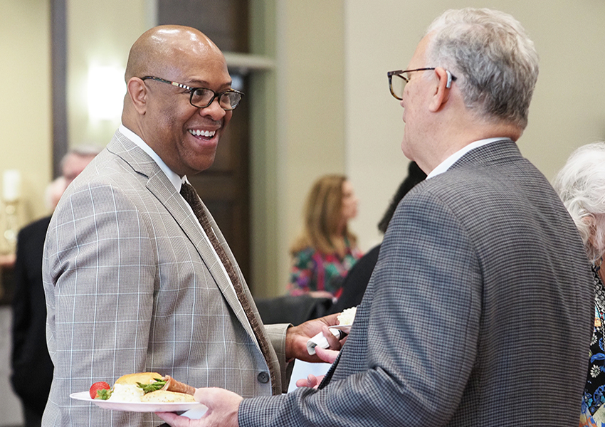 Dr. Mike Mitchell smiling speaking to alumni.