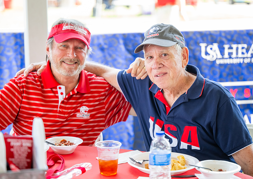 Two alumni smiling.