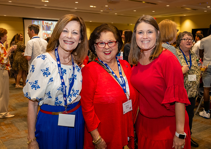 Three alumni smiling.