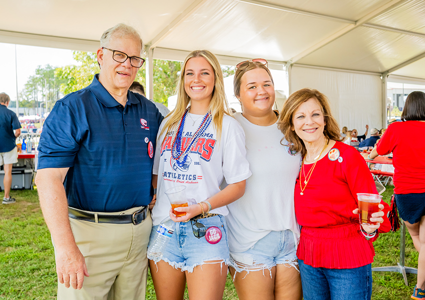 Four alumni smiling.