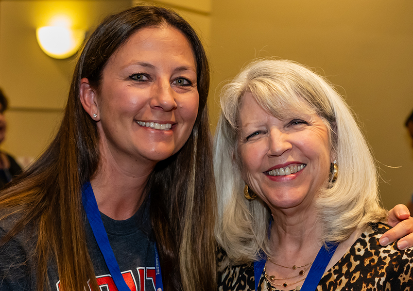 Two alumni smiling.