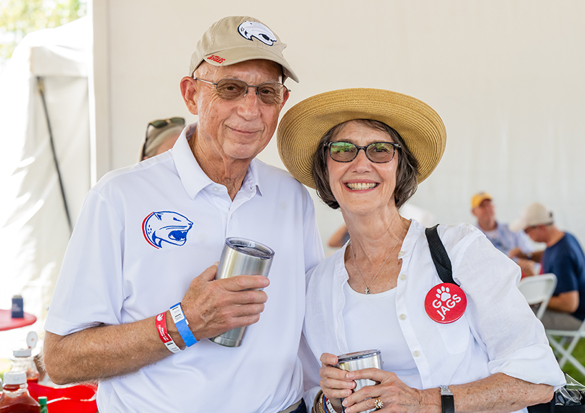 Two alumni smiling.