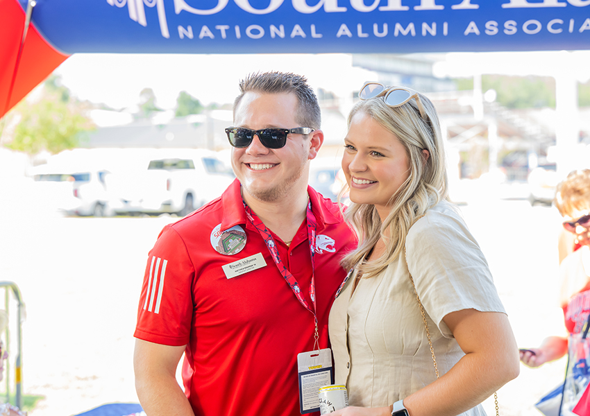 Two alumni smiling.