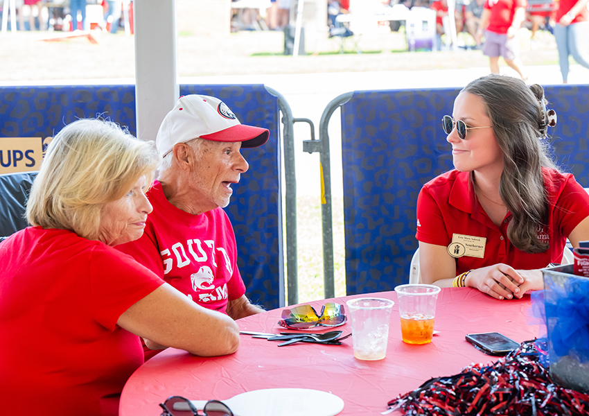 Three alumni smiling.