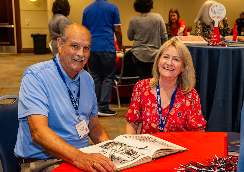 Two alumni smiling.