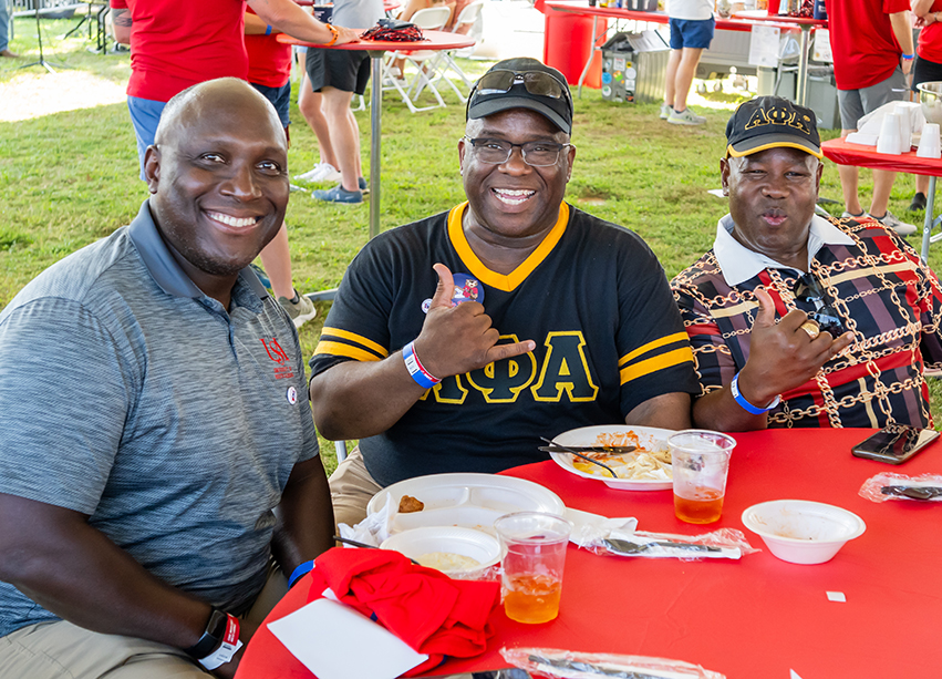 Three alumni smiling.