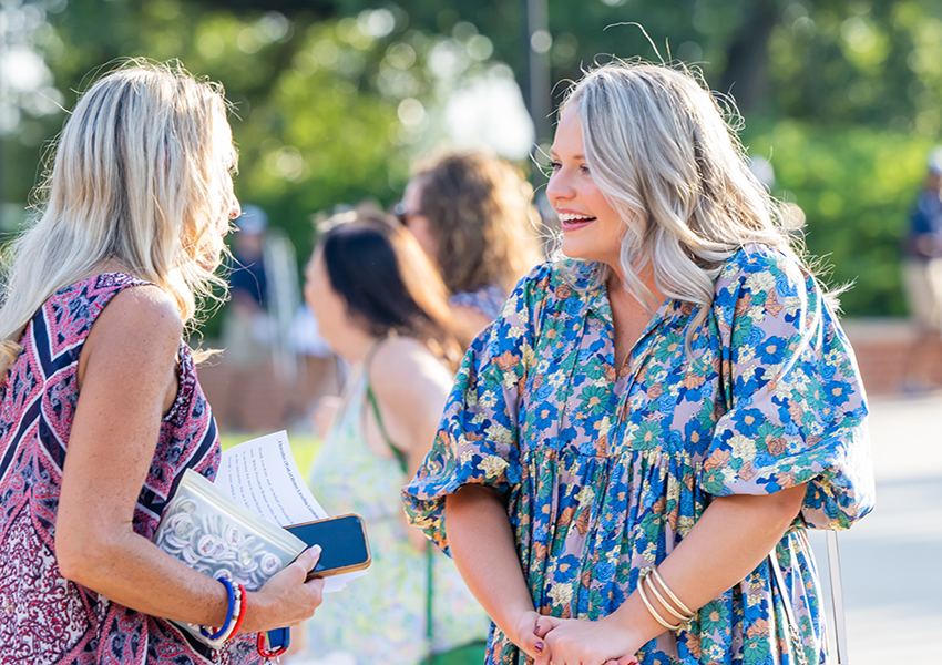 Woman in floral dress speaking to Dr. Andi Kent.