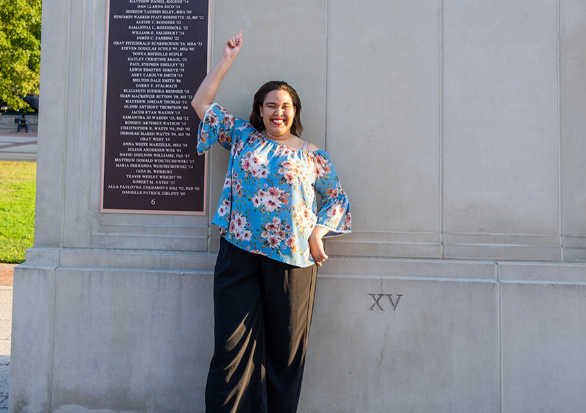 Woman pointing up to Wall of Honor.