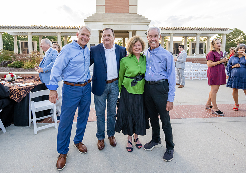 Geri Moulton and three men in front of Moulton Tower.