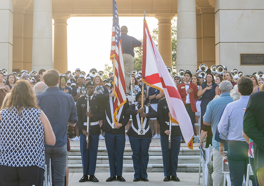 Military holding flags at ceremony.