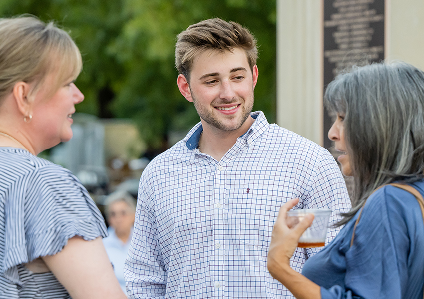 Three people talking at event.